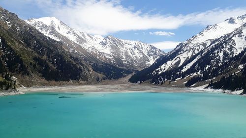 Scenic view of lake and snowcapped mountains against sky