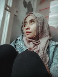 Portrait of a young woman looking away at home