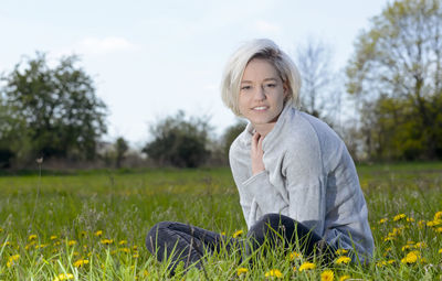 Portrait of smiling woman sitting on land