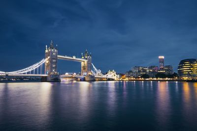 View of illuminated bridge over river against cloudy sky