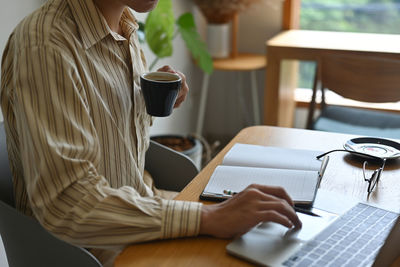 Rear view of man using laptop