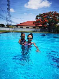 Portrait of mother and little daughter in swimming pool