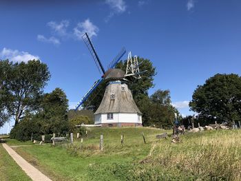 Traditional windmill on field against sky