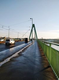 Suspension bridge over river against clear sky