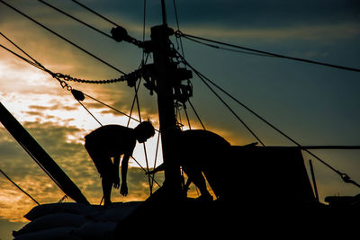 Low angle view of silhouette man against orange sky