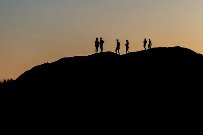 Silhouette of a group of people against sunset