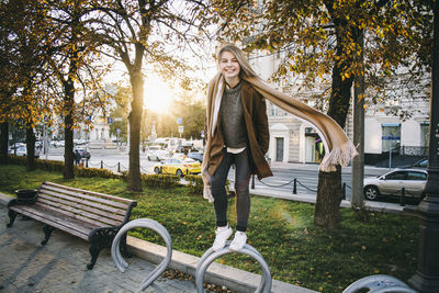 Woman standing on tree trunk