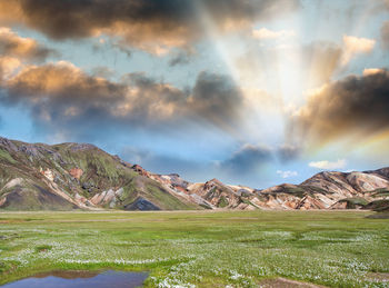 Scenic view of field and mountains against sky