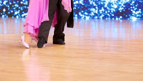 Low section of women standing on hardwood floor