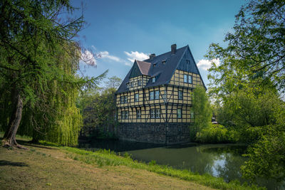 Building by lake against sky