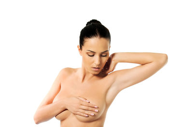 Topless woman covering breast against white background