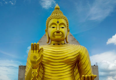 Low angle view of statue against temple against sky