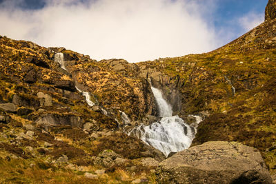 Scenic view of waterfall against sky