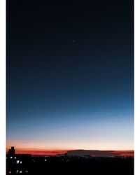 Silhouette landscape against clear sky at night