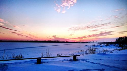 Scenic view of frozen lake against sky during sunset