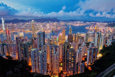 High angle view of city buildings against cloudy sky