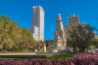 View of building and trees against blue sky