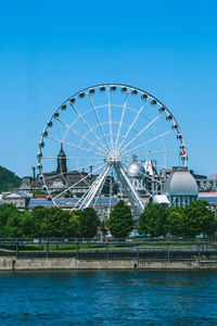 Ferris wheel in city against blue sky