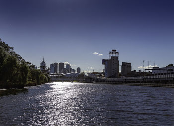 River and buildings against clear sky