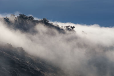 Scenic view of mountains against cloudy sky