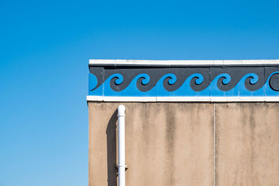 Low angle view of sign against clear blue sky