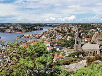 High angle view of townscape by sea against sky