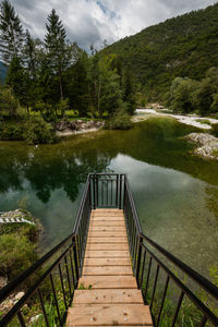 Footbridge over lake against trees