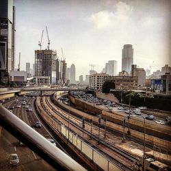 Railroad tracks in city against sky