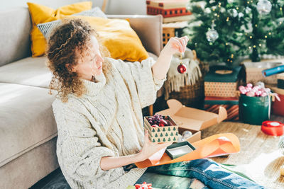 High angle view of mother and daughter sitting on sofa at home