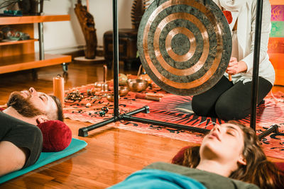 Therapist playing equipment while performing music therapy at spa