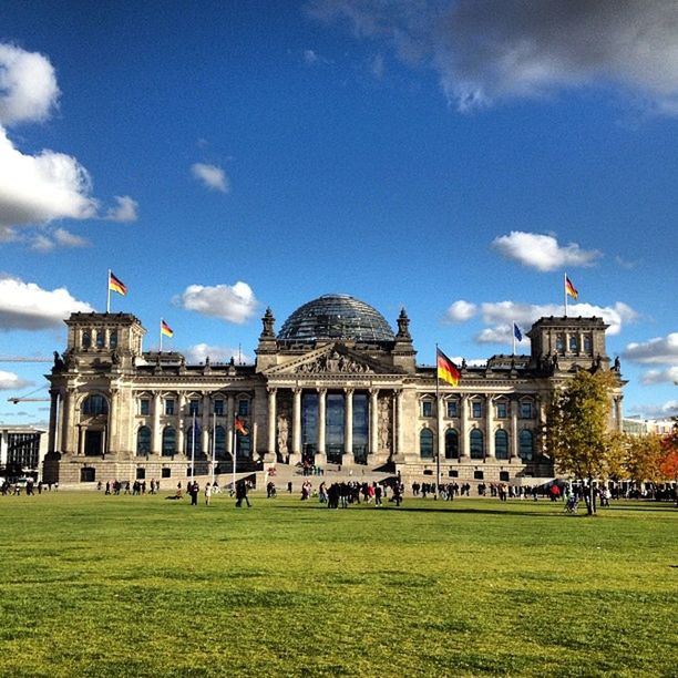 architecture, building exterior, built structure, grass, sky, famous place, cloud - sky, large group of people, travel destinations, tourism, tourist, history, lawn, travel, facade, person, cloud, men, international landmark