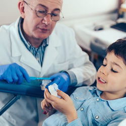 Cropped image of dentist examining boy at clinic