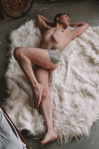 High angle view of shirtless woman lying at home
