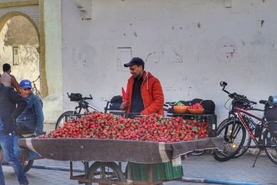 People with bicycle standing against wall