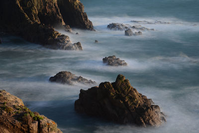 Rock formation in sea against sky