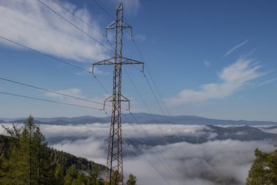 Low angle view of electricity pylon against sky