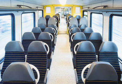 Passenger train interior with empty seats in motion, in bright light. train travel in germany.