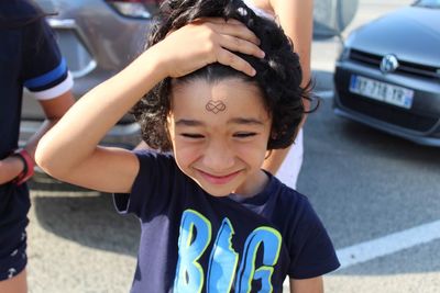 Close-up of boy showing drawing on forehead while standing on road