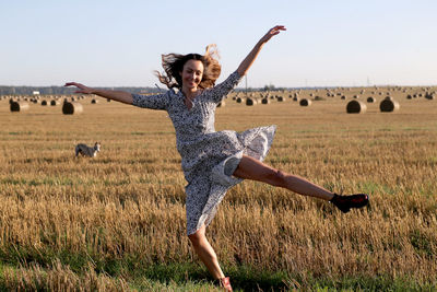 Full length of young woman doing yoga on field