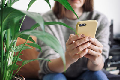 Midsection of woman using mobile phone outdoors