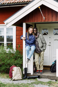 Portrait of a smiling young woman against building