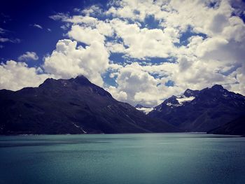 Scenic view of lake and mountains against cloudy sky