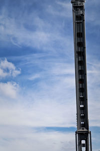 Low angle view of metallic pole against blue sky