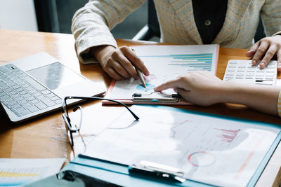 Midsection of business colleagues working at desk in office