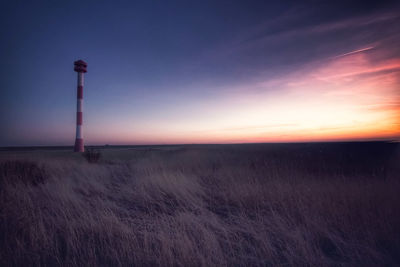 Scenic view of field against sky at sunset