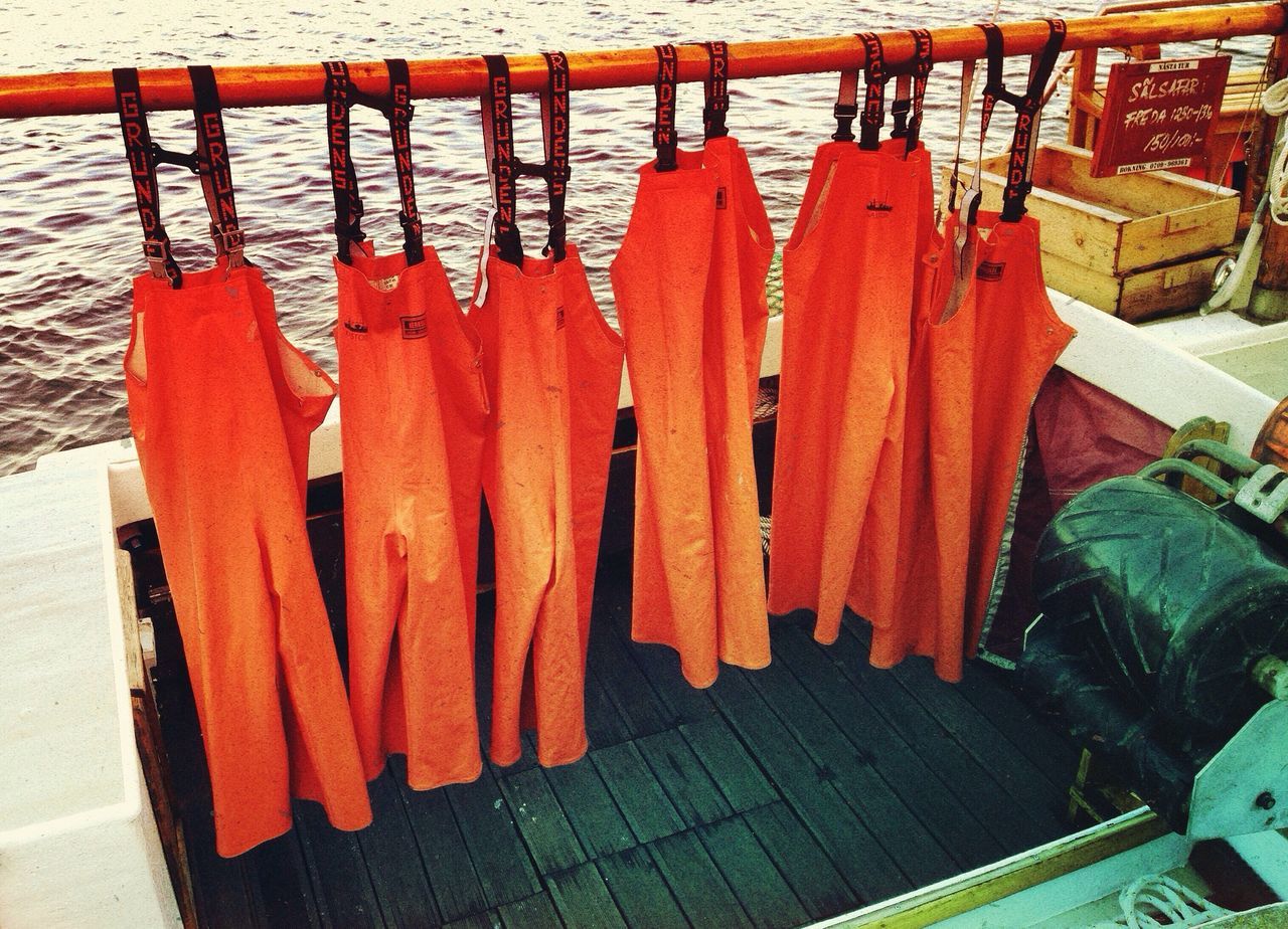 water, wood - material, high angle view, red, in a row, day, outdoors, no people, large group of objects, chair, table, side by side, arrangement, wooden, sunlight, close-up, orange color, railing, abundance, still life