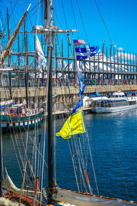 Sailboats moored in sea against blue sky