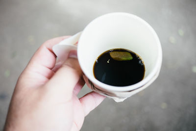 Close-up of hand holding coffee cup
