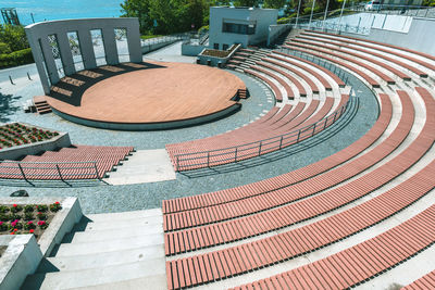 High angle view of empty chairs by swimming pool against buildings