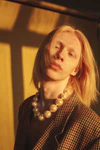 Man wearing pearl necklace in sunlight